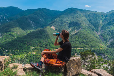 Man sitting on mountain looking at mountains