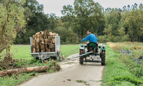 Man riding tractor and pulling tree trunk