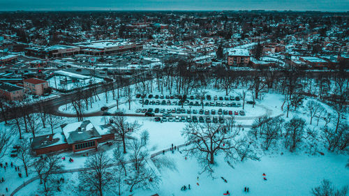 High angle view of snow covered trees and buildings in city