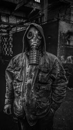 Mid adult man wearing gas mask while standing outdoors