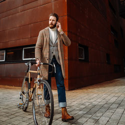 Full length of man walking with bicycle