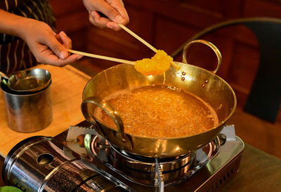 Midsection of person preparing food in kitchen