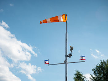 Windscock and flag flutter in the wind on a tall pole. the weather station measures the wind speed