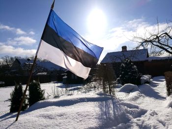 Low angle view of flag on snow covered landscape