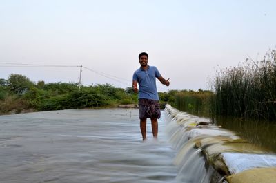 Full length of man standing on shore against sky