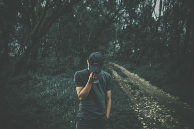 Full length of young man standing in forest