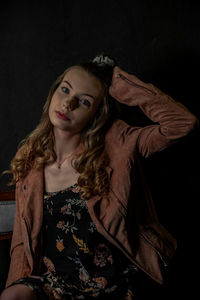 Portrait of woman against black background