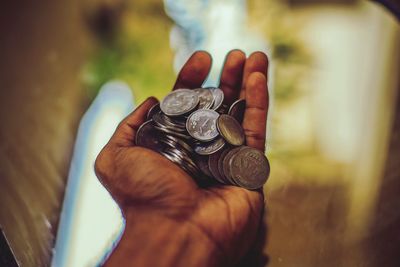 Close-up of hand holding coins