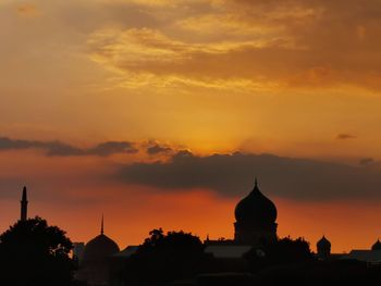 Silhouette buildings against sky during sunset