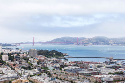 High angle view of city by sea against sky