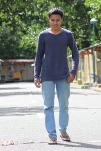 Full length of young man walking on road