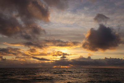 Scenic view of sea against dramatic sky during sunset