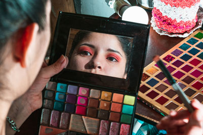 Beautiful latina woman sitting in front of her dressing table looking in the mirror