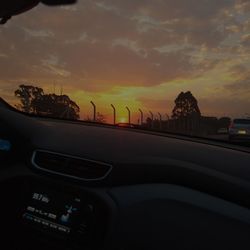 Road seen through car windshield during sunset