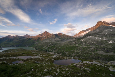 Scenic view of lake and mountains against sky at sunset