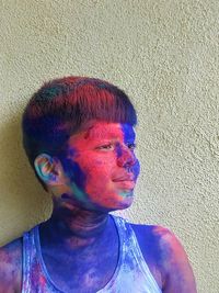 Portrait of young man wearing sunglasses against wall