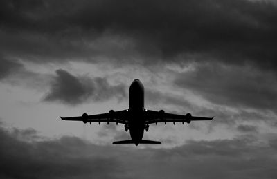 Low angle view of airplane flying against sky