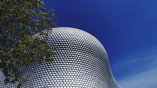 Low angle view of modern building against blue sky