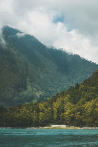 Scenic view of trees and mountains against sky