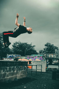 Man jumping in mid-air against sky