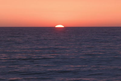 Scenic view of sea against orange sky
