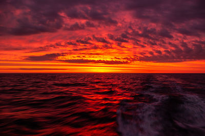 Scenic view of sea against dramatic sky during sunset