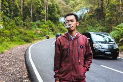 Portrait of young man standing on road