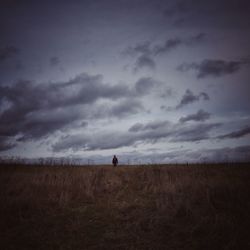 Scenic view of field against cloudy sky