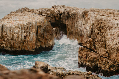 Scenic view of rocks in sea against sky