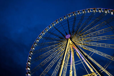 Low angle view of ferris wheel against clear blue sky