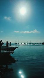 Sailboats moored on sea against sky