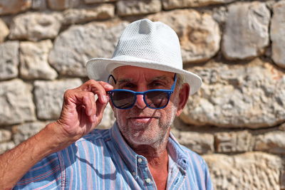 Portrait of man wearing sunglasses hat