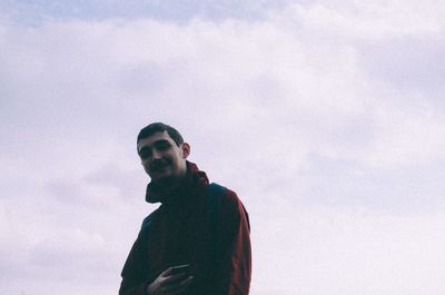 Low angle view of young man against sky