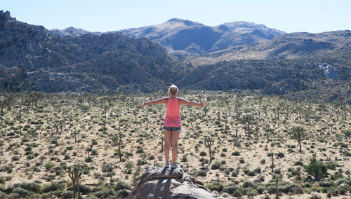 Full length of woman standing on mountain against clear sky