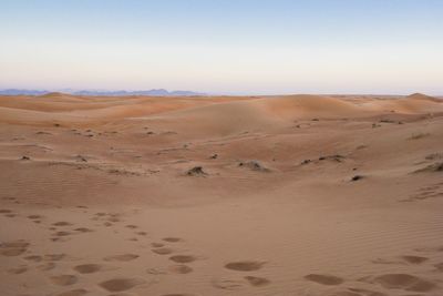 Sand dunes in desert against clear sky