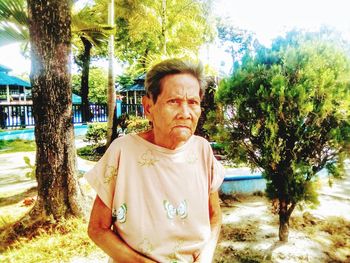 Portrait of man standing against trees