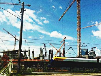 Low angle view of electricity pylon against blue sky