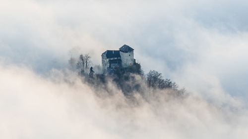 Scenic mystic view of a castle sourrounded by fog