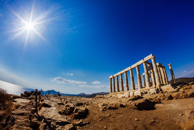 Temple of poseidon against blue sky on sunny day