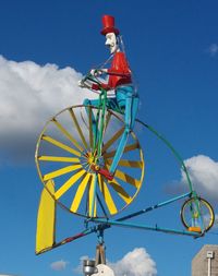 Low angle view of ferris wheel against blue sky