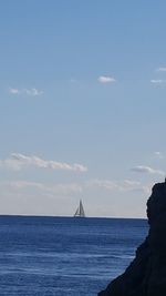 Sailboat sailing on sea against sky