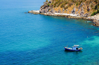 High angle view of fishing boat moored on sea by mountain