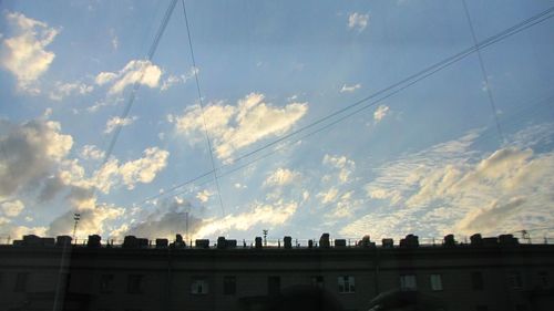 Low angle view of buildings against cloudy sky