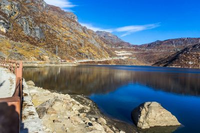 Scenic view of lake and mountains against blue sky