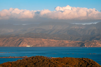 Scenic view of sea and mountains against sky