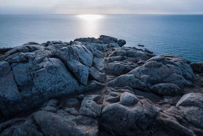 Rocks on sea shore against sky