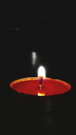 Close-up of lit candle in dark room