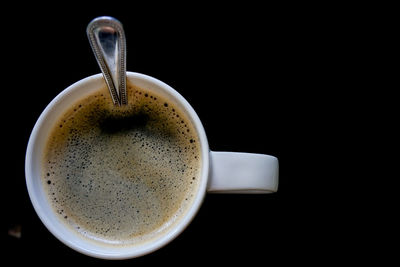 Directly above shot of coffee cup against black background