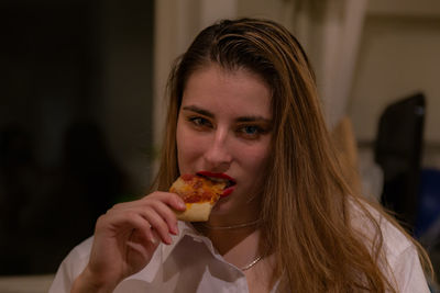 Portrait of woman eating pizza