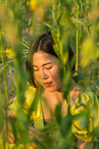 Portrait of young woman with plants in field